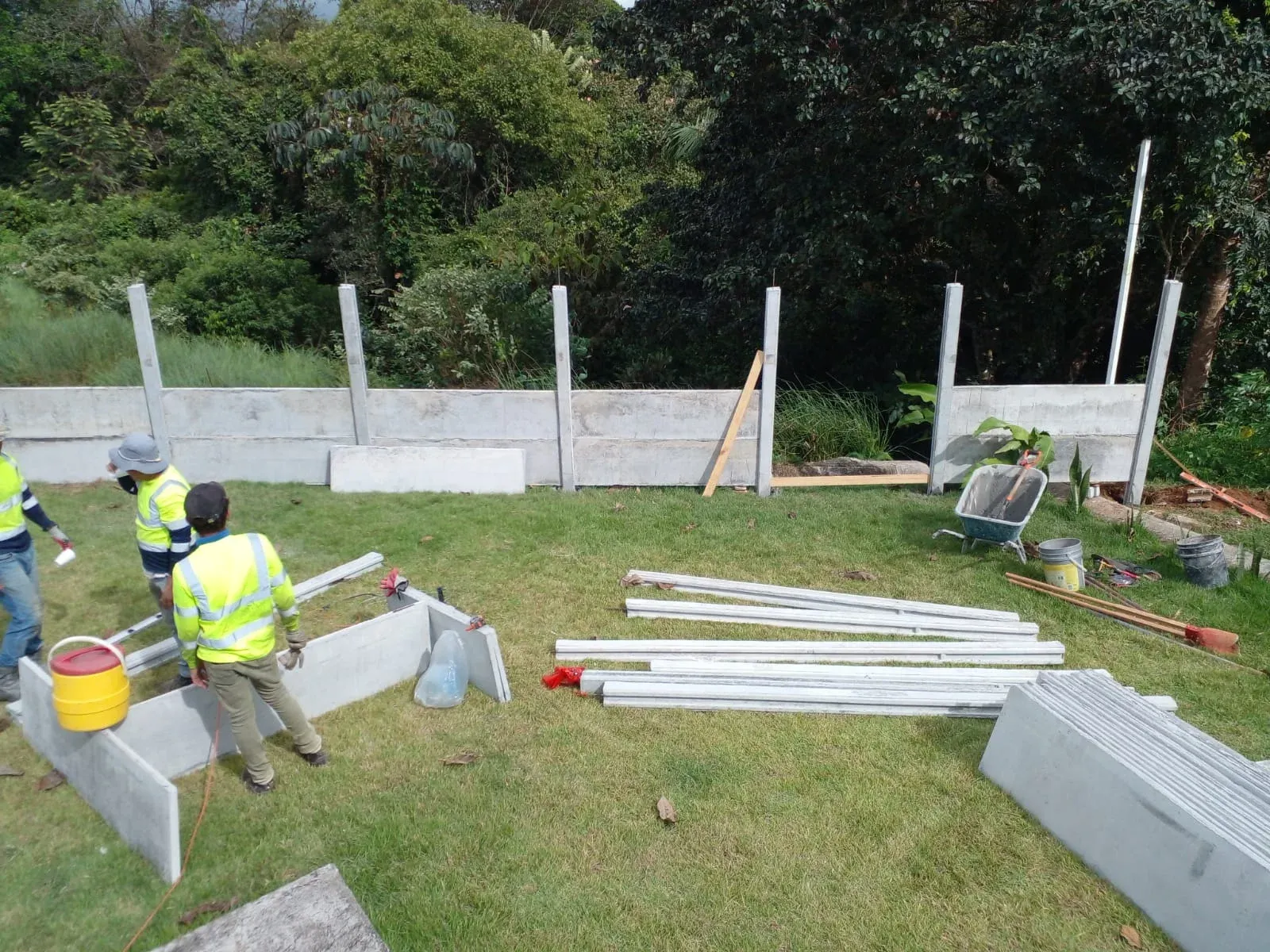 Cuadrilla instalando columnas y bases de muro perimetral prefabricado en obra residencial