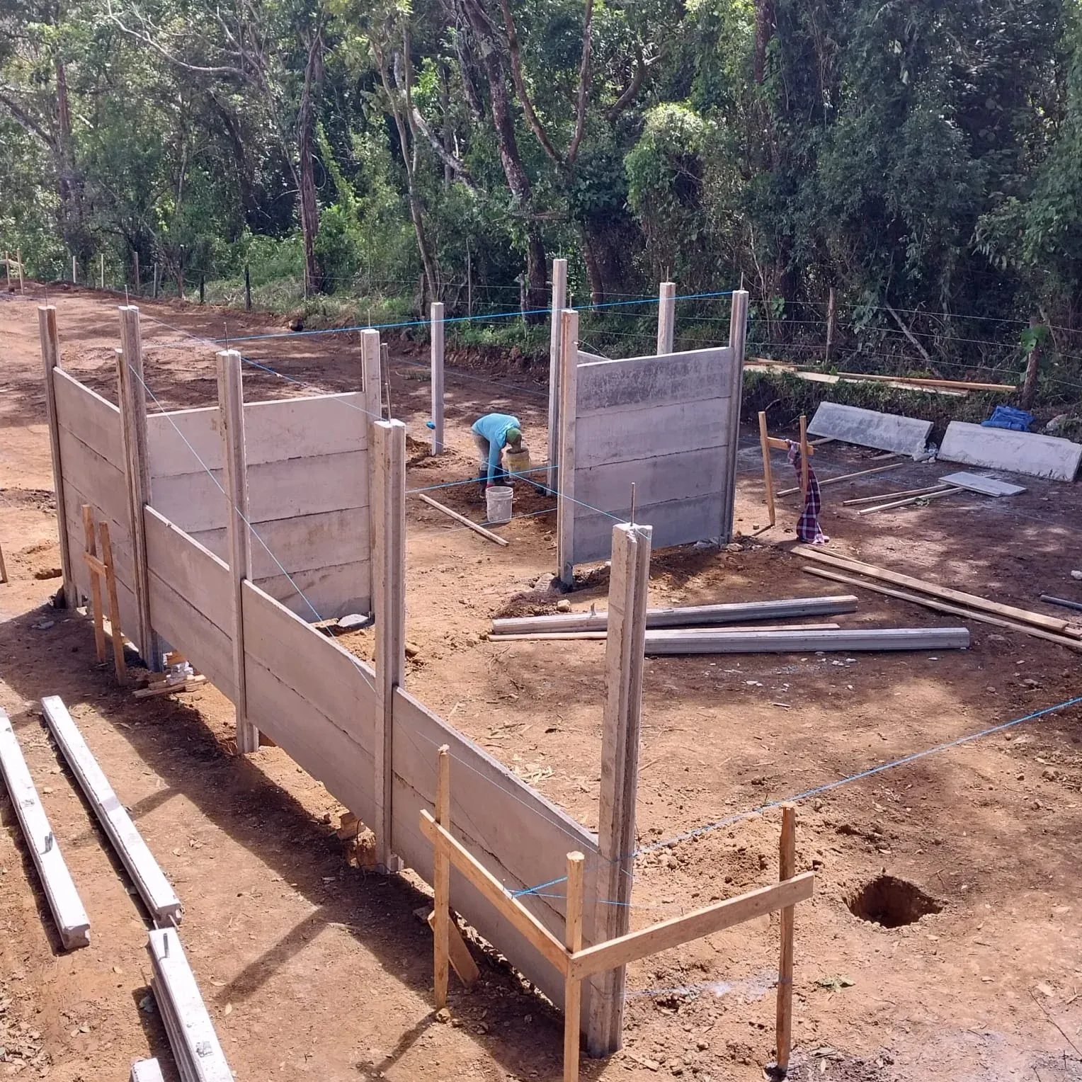 Estructura inicial de casa prefabricada con columnas verticales nuevas en lote en preparación
