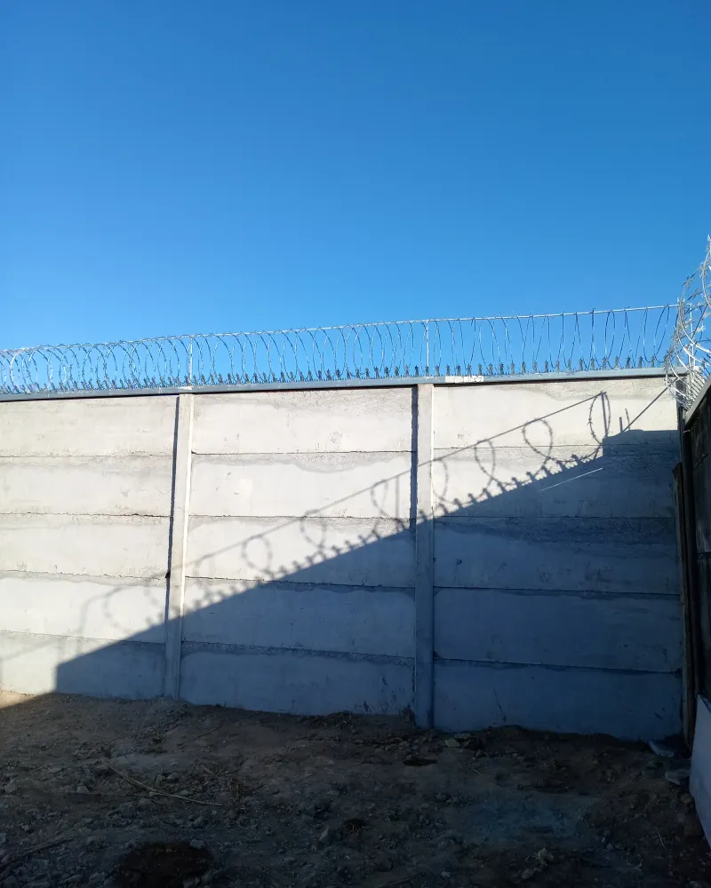 Muro Prefalego FORTEXA de alta seguridad con concertina de alambre de púas en perímetro industrial